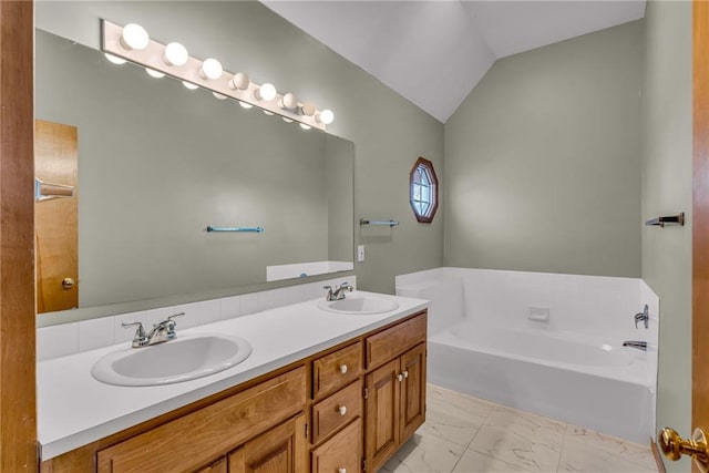 bathroom featuring lofted ceiling, a bathing tub, and vanity