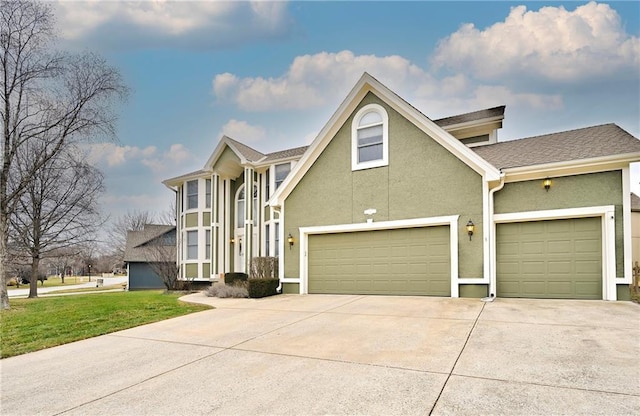 traditional-style home with driveway, a front lawn, and stucco siding