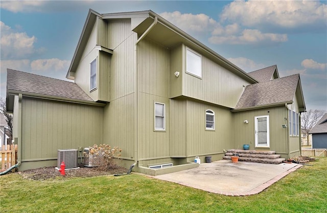 rear view of house featuring a yard, roof with shingles, a patio, and central air condition unit