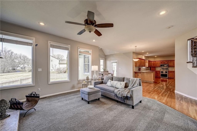 living room with recessed lighting, plenty of natural light, baseboards, and wood finished floors