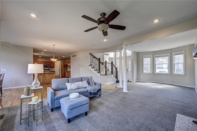 living room with decorative columns, visible vents, baseboards, stairway, and recessed lighting