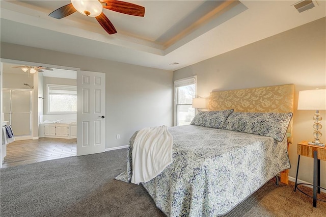 bedroom featuring a ceiling fan, visible vents, baseboards, carpet, and a raised ceiling