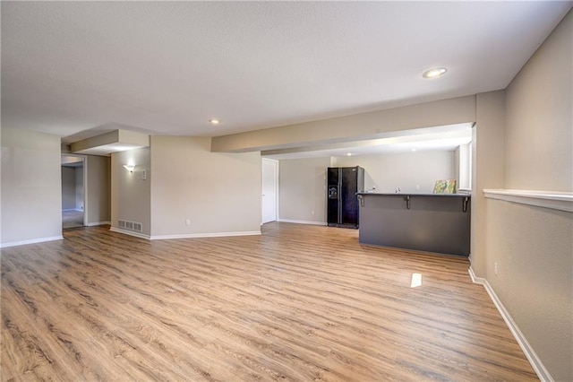 unfurnished living room featuring recessed lighting, visible vents, baseboards, and wood finished floors