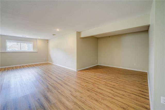 spare room with light wood-type flooring and baseboards