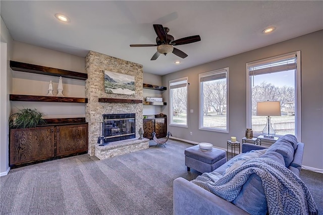 carpeted living room with a stone fireplace, plenty of natural light, recessed lighting, and baseboards