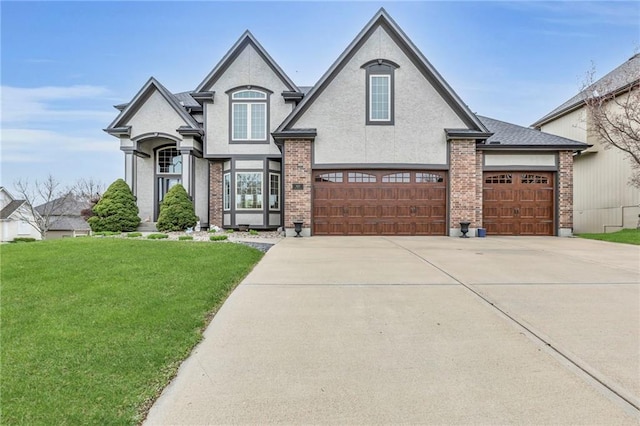 french country home with stucco siding, a front lawn, driveway, and brick siding