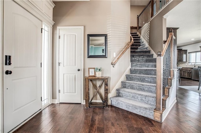 foyer entrance featuring stairway, dark wood-style floors, and baseboards