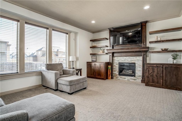 carpeted living room with a stone fireplace, recessed lighting, a textured ceiling, and crown molding