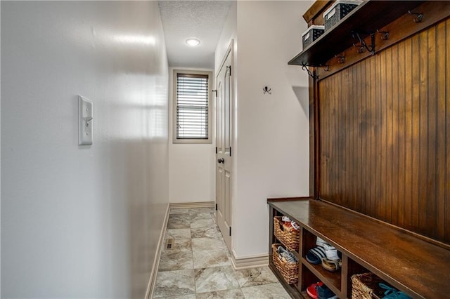 mudroom featuring baseboards and a textured ceiling