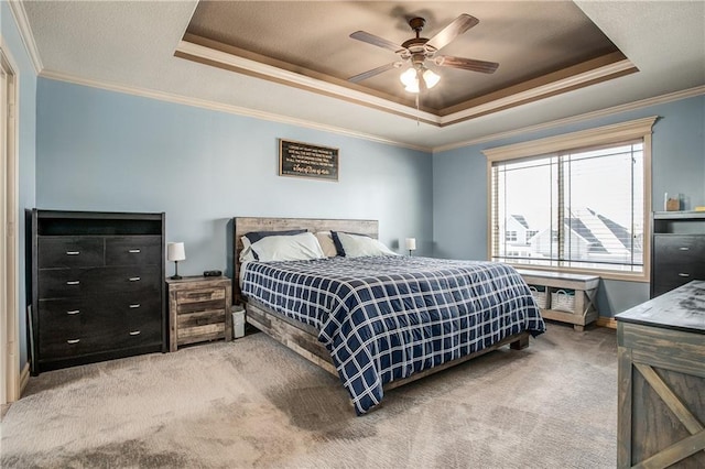 bedroom featuring a raised ceiling, carpet floors, ceiling fan, and crown molding