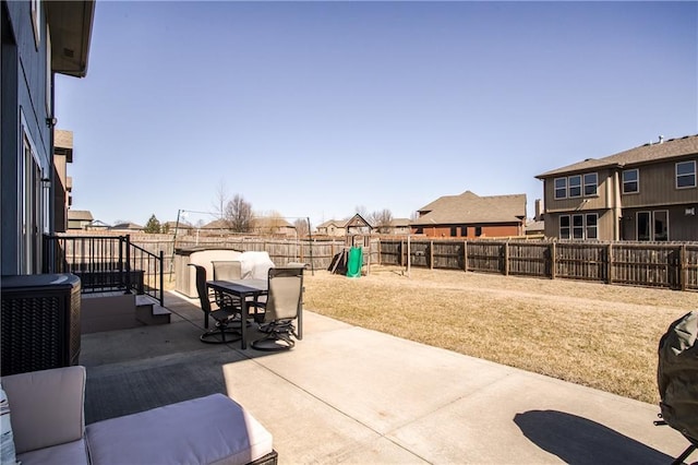 view of patio with outdoor dining space, a fenced backyard, and a residential view