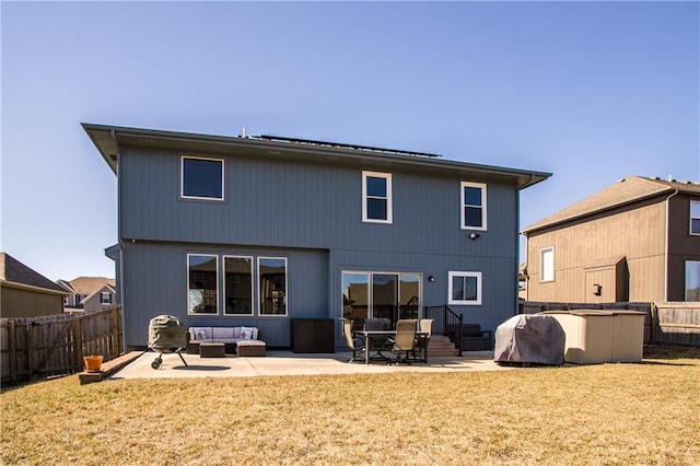 back of property with a patio area, an outdoor living space, a yard, and a fenced backyard