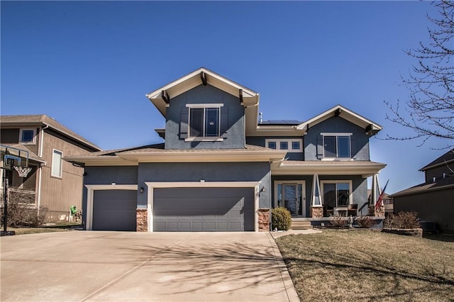 view of front of home with roof mounted solar panels, stucco siding, driveway, and covered porch