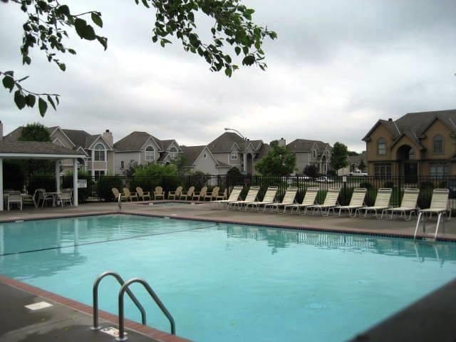 community pool with a residential view, a patio, and fence