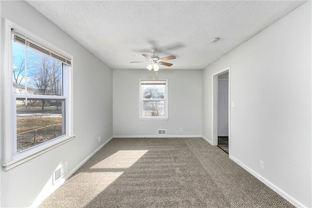 carpeted empty room with a textured ceiling and ceiling fan