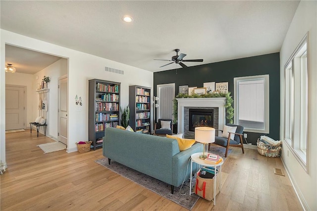 living room with ceiling fan and light hardwood / wood-style flooring