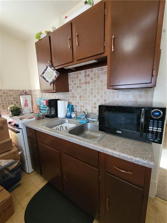 513 S Business Highway 13, Lexington, MO 64067 - kitchen with black microwave, a sink, light countertops, backsplash, and dark brown cabinetry