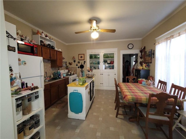513 S Business Highway 13, Lexington, MO 64067 - kitchen with a ceiling fan, white gas stove, light countertops, crown molding, and a kitchen island