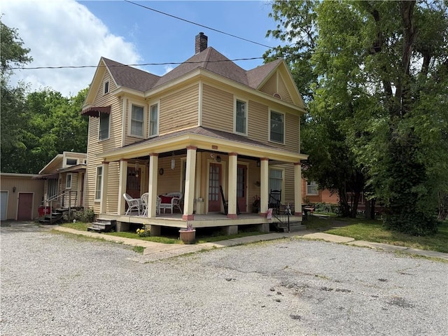 513 S Business Highway 13, Lexington, MO 64067 - view of front of home featuring a chimney, covered porch, and an outbuilding