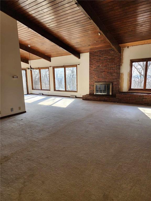 11425 45th Hwy N, Platte City, MO 64079 - unfurnished living room featuring wood ceiling, a fireplace, carpet flooring, and a chandelier