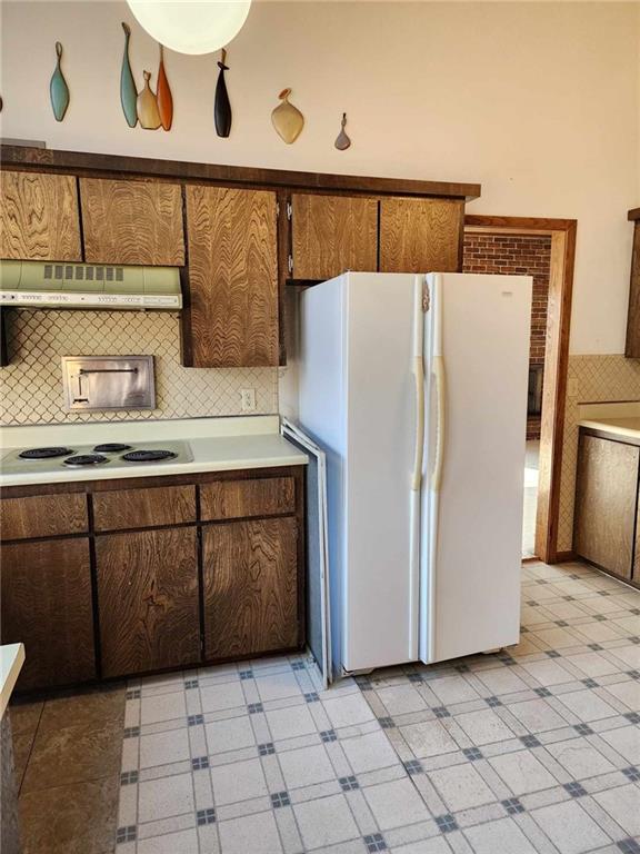 11425 45th Hwy N, Platte City, MO 64079 - kitchen with white appliances, ventilation hood, light floors, light countertops, and backsplash