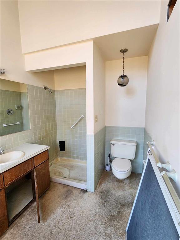 11425 45th Hwy N, Platte City, MO 64079 - full bath featuring tile walls, a shower stall, vanity, toilet, and a wainscoted wall