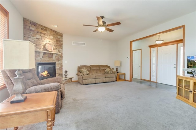 carpeted living room featuring baseboards, a fireplace, visible vents, and ceiling fan