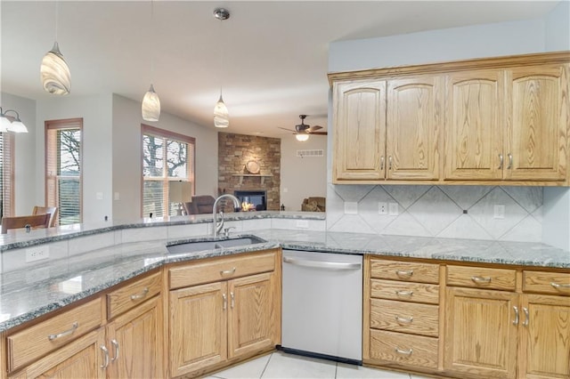 kitchen featuring a ceiling fan, a sink, backsplash, light stone countertops, and dishwasher