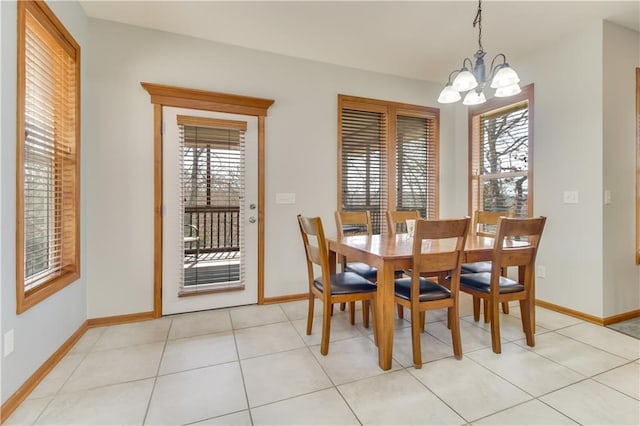 dining area featuring light tile patterned flooring, a notable chandelier, and baseboards