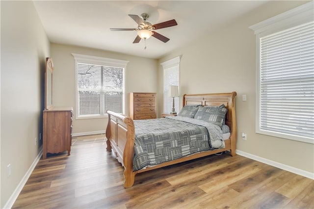 bedroom with ceiling fan, baseboards, and wood finished floors