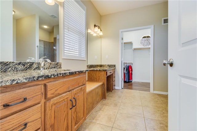 bathroom with visible vents, baseboards, a stall shower, tile patterned flooring, and a spacious closet