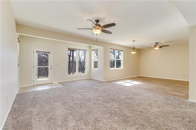 spare room featuring light carpet, baseboards, and ceiling fan