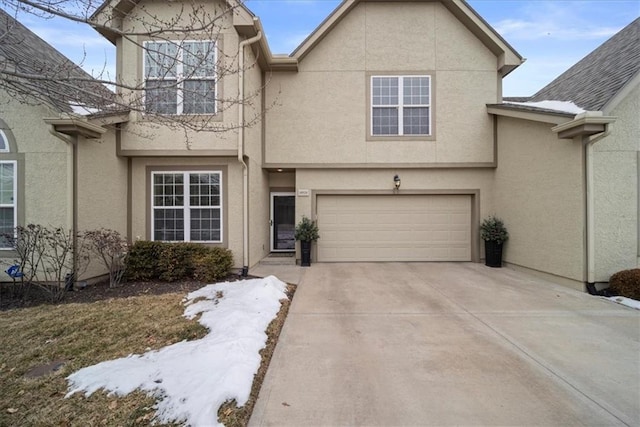 view of front of house with concrete driveway, an attached garage, and stucco siding