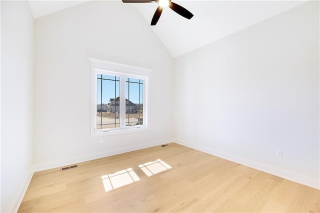 empty room with ceiling fan, high vaulted ceiling, and light wood-type flooring