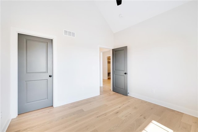 unfurnished bedroom featuring ceiling fan, high vaulted ceiling, and light hardwood / wood-style flooring