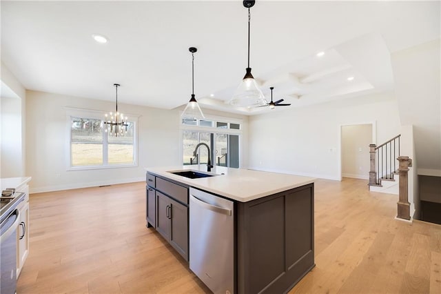 kitchen with sink, hanging light fixtures, a center island with sink, light hardwood / wood-style flooring, and stainless steel dishwasher