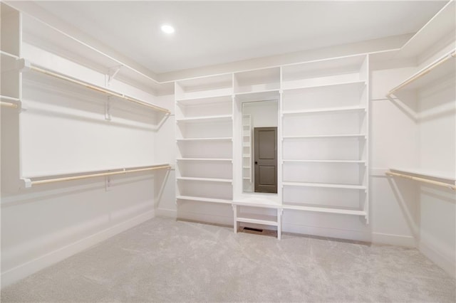 walk in closet featuring light colored carpet