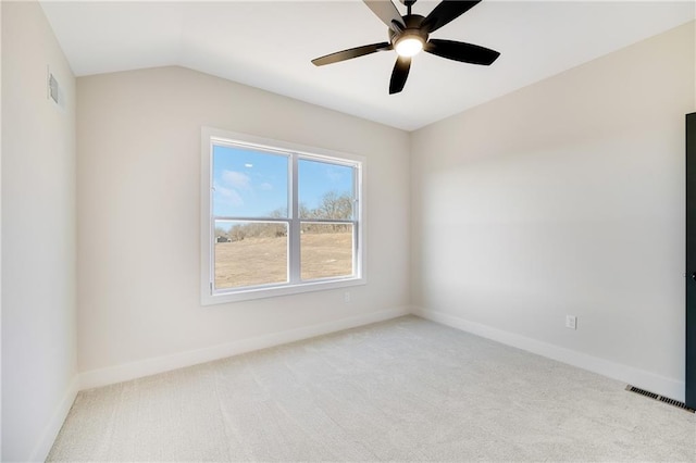 spare room with vaulted ceiling, light colored carpet, and ceiling fan