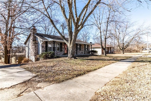 single story home with a garage, brick siding, and a chimney