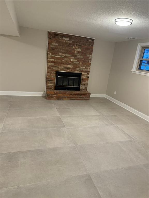 unfurnished living room featuring a textured ceiling and a fireplace