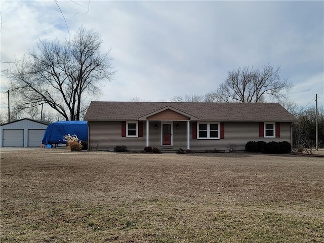 ranch-style home with a garage and an outbuilding