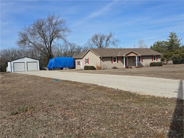 ranch-style house with covered porch, a detached garage, and an outdoor structure