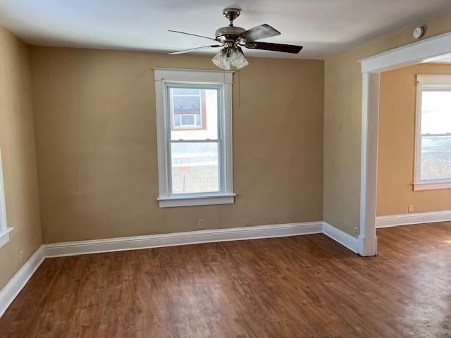 spare room with dark wood-type flooring and ceiling fan