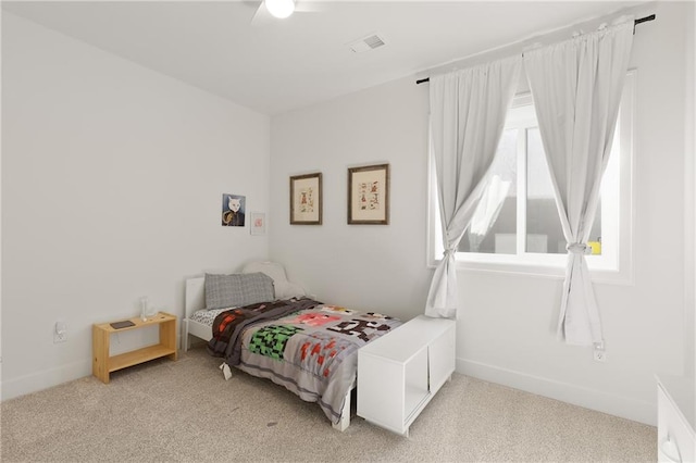 bedroom featuring a ceiling fan, light colored carpet, visible vents, and baseboards