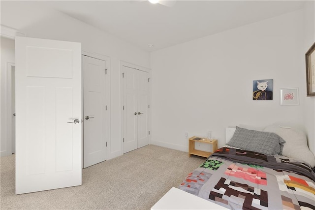 carpeted bedroom with baseboards and multiple closets