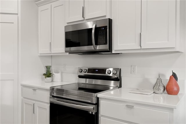 kitchen with light countertops, appliances with stainless steel finishes, and white cabinetry