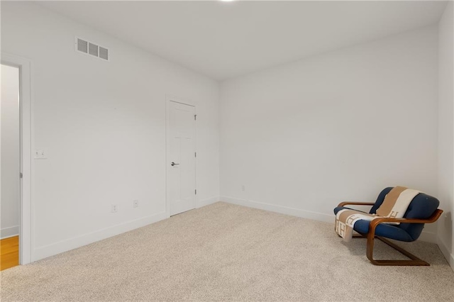 living area featuring carpet floors, baseboards, and visible vents