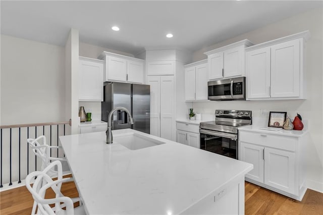 15171 W 173rd St, Olathe, KS 66062 - kitchen with white cabinets, a breakfast bar, a sink, a center island with sink, and appliances with stainless steel finishes