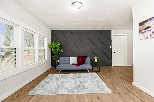 sitting room with light wood-type flooring and wood walls