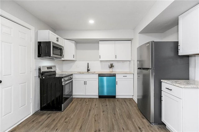 kitchen with appliances with stainless steel finishes, sink, dark hardwood / wood-style flooring, and white cabinets